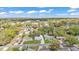 An aerial view of a neighborhood with tree-lined streets, well-manicured lawns, and houses with pools at 615 Carey Pl, Lakeland, FL 33803