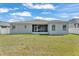 This home features a well-manicured backyard and exterior view of the screened in patio at 6185 Gracie Pl, Lakeland, FL 33812