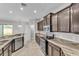 Well-equipped kitchen featuring granite countertops, dark wood cabinets, and modern appliances at 6185 Gracie Pl, Lakeland, FL 33812