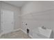 A functional laundry room includes tile floors, sink, and wire shelving above the utility connections at 6185 Gracie Pl, Lakeland, FL 33812