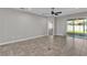 Bright living room with sliding glass doors leading to the lanai, neutral paint, and tile floors at 6185 Gracie Pl, Lakeland, FL 33812