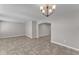 Spacious living room showcasing tile flooring, fresh paint, and an overhead chandelier at 6185 Gracie Pl, Lakeland, FL 33812