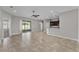 Open living area featuring tile flooring, ceiling fan, fresh paint and a view of the kitchen area at 6185 Gracie Pl, Lakeland, FL 33812