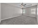 Main bedroom features a tray ceiling, ceiling fan, neutral paint, and carpeted floors at 6185 Gracie Pl, Lakeland, FL 33812