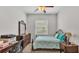 Bedroom with a decorative metal bed frame, neutral carpet, and a bright window view at 6923 Highlands Creek Ave, Lakeland, FL 33813