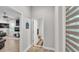 Hallway view into the powder bath, and view into the living room with wood flooring at 6923 Highlands Creek Ave, Lakeland, FL 33813