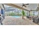 An outdoor screened pool area with a spa, barbecue, table, chairs, and ceiling fans at 6923 Highlands Creek Ave, Lakeland, FL 33813