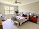 Bright bedroom featuring a ceiling fan, neutral walls, a double-hung window, and cozy furnishings at 7903 Lake James Blvd, Lakeland, FL 33810