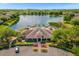 Stunning aerial view of community clubhouse, pool, and picturesque lake with fountain at 8160 Lake James Dr, Lakeland, FL 33810