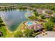 Scenic aerial view of a community lake with fountain, pool, and beautiful neighborhood homes at 8160 Lake James Dr, Lakeland, FL 33810