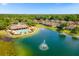 Aerial view of community clubhouse and pool overlooking a scenic lake with fountain feature at 8160 Lake James Dr, Lakeland, FL 33810