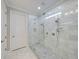 Walk-in shower with clear glass door and marble walls and floor tiles at 8160 Lake James Dr, Lakeland, FL 33810