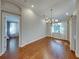 Bright dining room featuring hardwood floors, modern chandelier, and abundant natural light from large windows at 8160 Lake James Dr, Lakeland, FL 33810