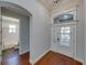 Inviting entryway with transom window over door, hardwood floors and view of bathroom to the left at 8160 Lake James Dr, Lakeland, FL 33810