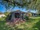 Home exterior featuring a screened lanai, landscaped yard and well-maintained lawn with shade trees at 8160 Lake James Dr, Lakeland, FL 33810