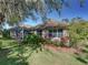 Home exterior showcasing a screened lanai and lush landscaping with colorful plantings at 8160 Lake James Dr, Lakeland, FL 33810