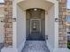 Covered front entry shows stone accents and tiled floor leading to the main door with security door at 8160 Lake James Dr, Lakeland, FL 33810