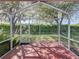 Screened lanai providing a relaxing outdoor space with views of lush landscaping and mature trees at 8160 Lake James Dr, Lakeland, FL 33810