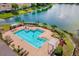 Aerial view of community swimming pool with lounge chairs, pergolas and lakeside views at 8160 Lake James Dr, Lakeland, FL 33810