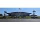 Community clubhouse featuring an American flag, mature landscaping, and ample parking at 1007 Forest Lake Dr, Lakeland, FL 33809