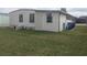 Exterior view of home featuring horizontal siding, lawn, and storage containers at 1007 Forest Lake Dr, Lakeland, FL 33809