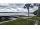 Beautiful lake view with boat dock and grass and palm trees in a lush landscaping at 1007 Forest Lake Dr, Lakeland, FL 33809