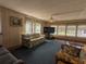 Spacious living room with large windows, ceiling fan, and cozy seating provides a comfortable gathering space at 1007 Forest Lake Dr, Lakeland, FL 33809