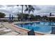 Community pool with a lake view, umbrellas, and plenty of lounge seating at 1007 Forest Lake Dr, Lakeland, FL 33809