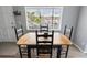 Charming dining area with wooden table and chairs, bathed in natural light from a large window at 1100 Martinique Dr # 202, Winter Haven, FL 33884