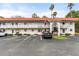 Well-maintained two-story condo building featuring palm trees and ample parking spaces at 1100 Martinique Dr # 202, Winter Haven, FL 33884