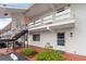 Condo building with exterior stairs leading to units above, surrounded by manicured landscaping at 1100 Martinique Dr # 202, Winter Haven, FL 33884