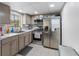 Efficient kitchen with stainless steel appliances, light wood cabinets, and modern fixtures at 1100 Martinique Dr # 202, Winter Haven, FL 33884