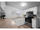 Well-lit kitchen featuring white cabinets and modern stainless steel appliances at 1115 S Virginia Ave, Bartow, FL 33830