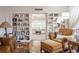 Cozy living room with hardwood floors and built-in shelving, with a glimpse into another living space with lots of natural light at 112 E Graham Park Dr, Haines City, FL 33844