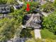 Aerial view of a gray two-story home in a tree-filled neighborhood with a long driveway and a manicured lawn at 1134 Waterfall Ln # 66, Lakeland, FL 33803