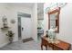 Bright foyer with gray wood-look floors, an entry table and mirror and a view into an eat-in kitchen at 1134 Waterfall Ln # 66, Lakeland, FL 33803