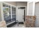 Welcoming front porch with a decorative bench, brick accents, and a sidelight window next to the front door at 1134 Waterfall Ln # 66, Lakeland, FL 33803