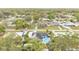 High aerial view of a single-story home featuring an in-ground pool, solar panels, and many mature trees at 1160 Ilene Ave, Bartow, FL 33830