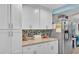 Clean and organized kitchen featuring white cabinets, granite countertops, and mosaic backsplash at 1160 Ilene Ave, Bartow, FL 33830