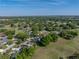 An aerial view captures a home with a pool amidst lush landscapes and distant cityscapes at 121 Greenfield Rd, Winter Haven, FL 33884