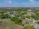 An aerial perspective highlights a home with a pool near a golf course and scenic surroundings at 121 Greenfield Rd, Winter Haven, FL 33884