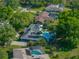 Aerial view of a home with solar panels and a swimming pool nestled among lush greenery at 121 Greenfield Rd, Winter Haven, FL 33884