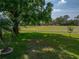 Expansive backyard featuring a well-maintained lawn, mature trees, and ample space for outdoor activities and recreation at 121 Greenfield Rd, Winter Haven, FL 33884