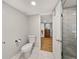 Clean bathroom with modern toilet, white tile flooring, and glass shower door, showcasing simplicity and functionality at 121 Greenfield Rd, Winter Haven, FL 33884