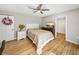 Bedroom features wood floors, ceiling fan, and ensuite bathroom, providing a serene and functional living space at 121 Greenfield Rd, Winter Haven, FL 33884