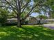 Beautiful single-story home with a well-maintained lawn, mature trees, and stone facade at 121 Greenfield Rd, Winter Haven, FL 33884