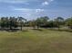 Scenic view of a green space with mature trees and a well-manicured lawn, offering a tranquil and picturesque setting at 121 Greenfield Rd, Winter Haven, FL 33884