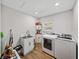 Well-lit laundry room with modern appliances, storage cabinets, and wood-look flooring at 121 Greenfield Rd, Winter Haven, FL 33884