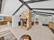 Well-lit living room with exposed beams, stone fireplace, and open layout to the kitchen and dining area at 121 Greenfield Rd, Winter Haven, FL 33884