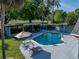 Inviting pool with umbrella and lounge chairs for relaxation and fun in a backyard oasis at 121 Greenfield Rd, Winter Haven, FL 33884